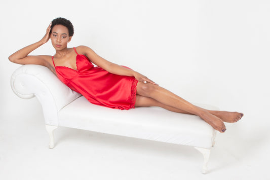 woman in red sleeveless dress sitting on white couch