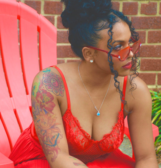 woman in red and black floral tank top sitting on pink chair