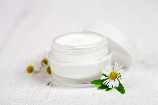 A jar of cream sitting on top of a white table