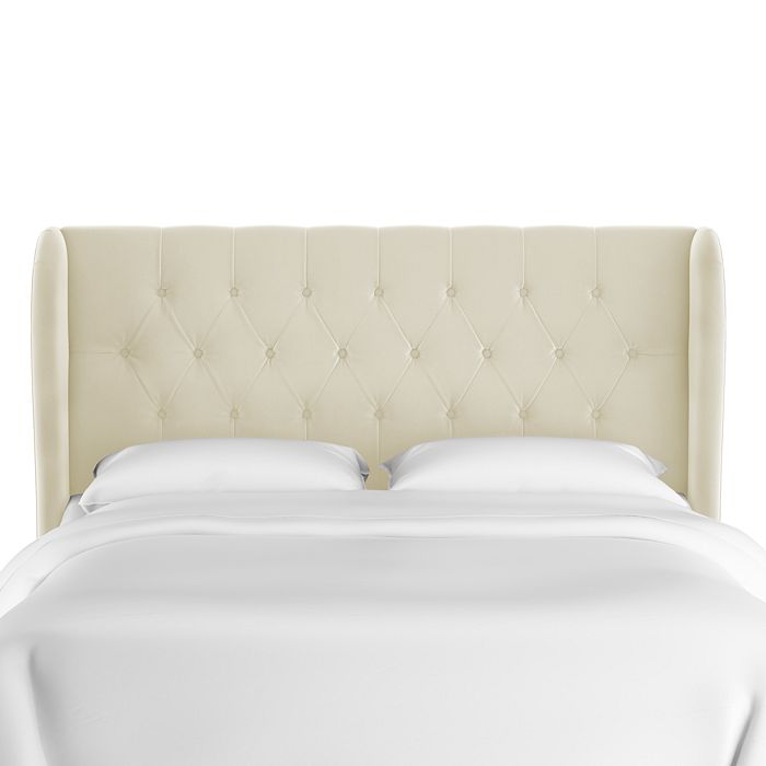 a white bed with white sheets and pillows