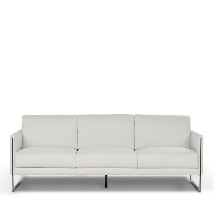 a white couch sitting in a room next to a white wall