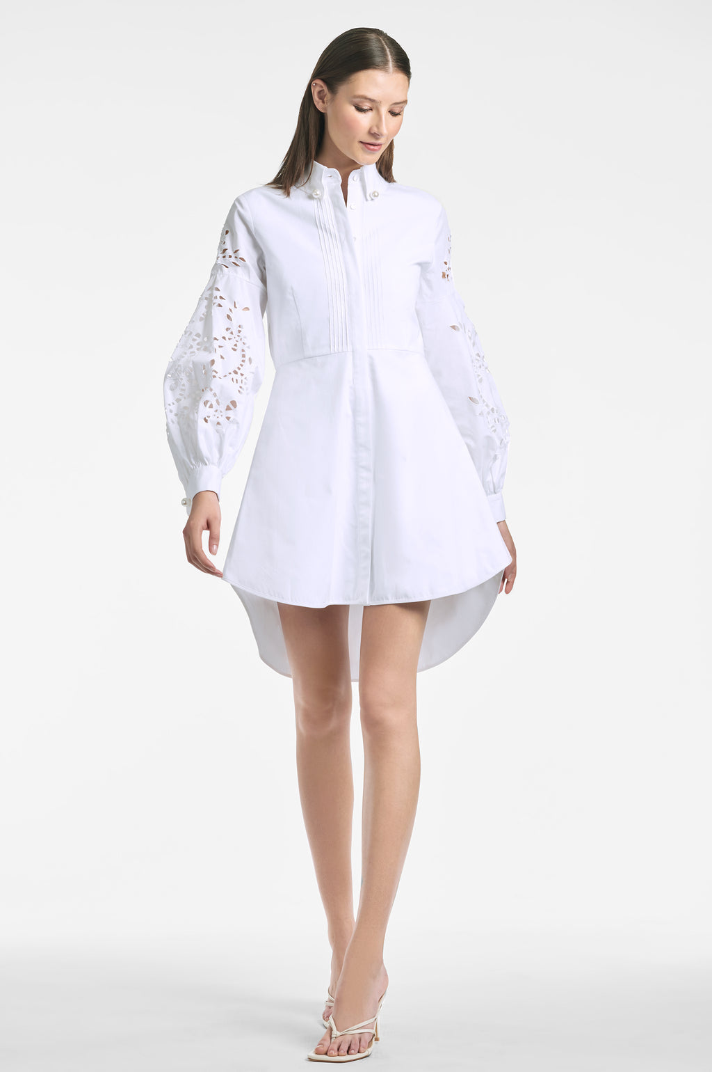 a woman in a white dress holding a tennis racquet