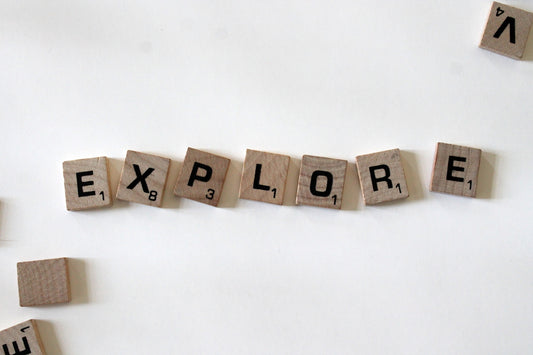 flat lay photography of scrabble tiles forming explore word