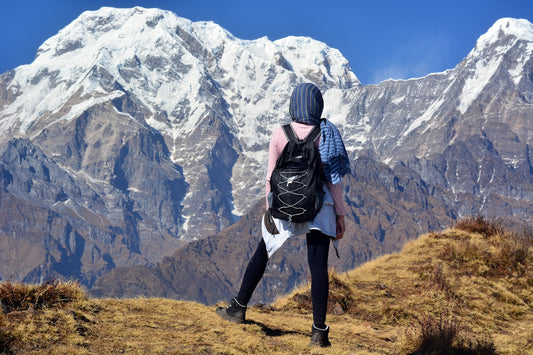 person carrying black backpack across white mountain