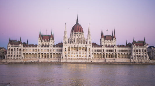 a large white building with a red dome next to a body of water