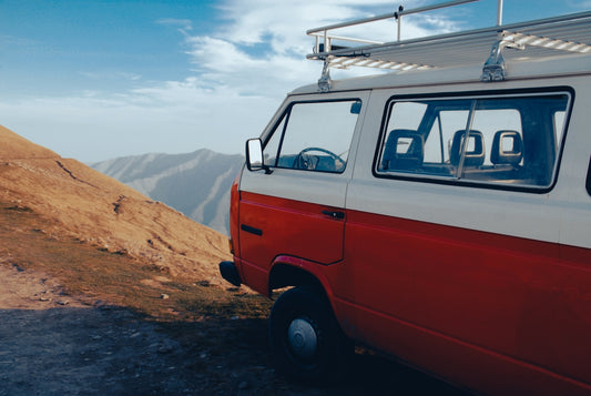 a red van parked on a dirt road