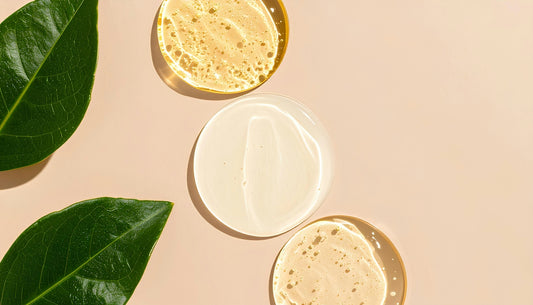 Skincare products with green leaves on a beige surface