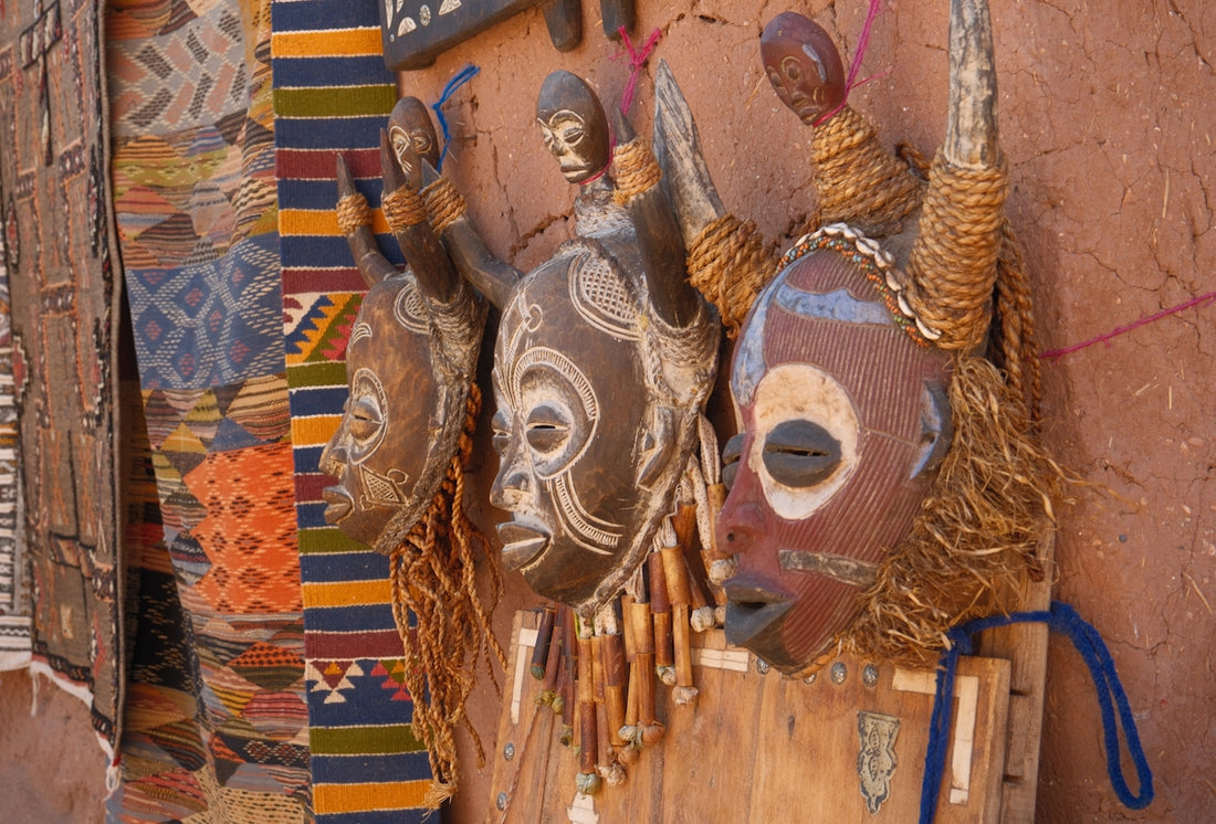 Three tribal masks with horns hanging on wall.