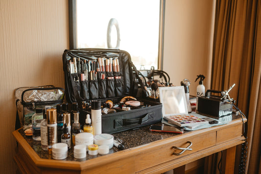 Makeup artist's kit spread across a wooden vanity table