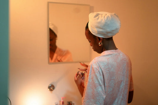 Woman applying makeup in front of a mirror
