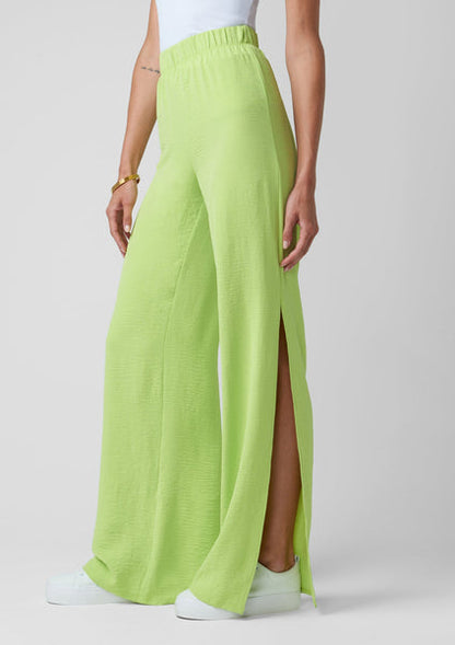 a person in a green dress standing on a beach 