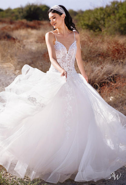 a woman in a white dress sitting on a bed 