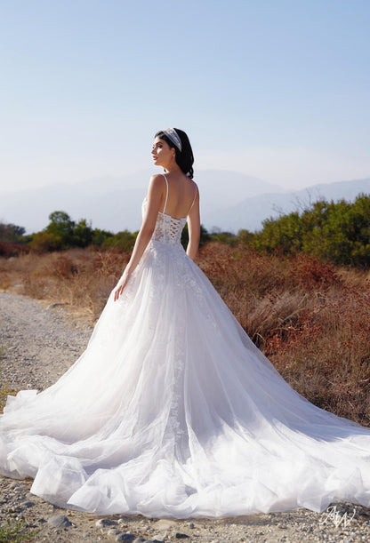 a woman in a white dress is sitting on a bench 