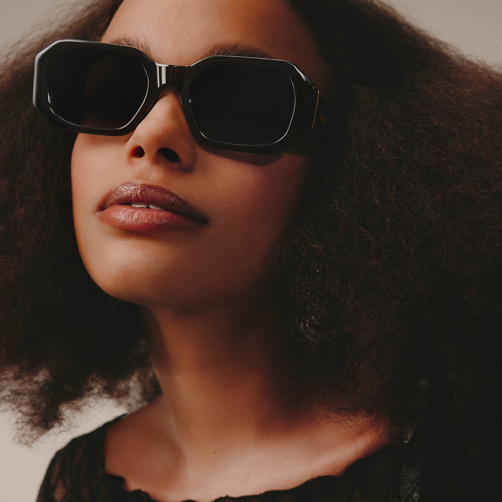 a woman wearing sunglasses and a hat 